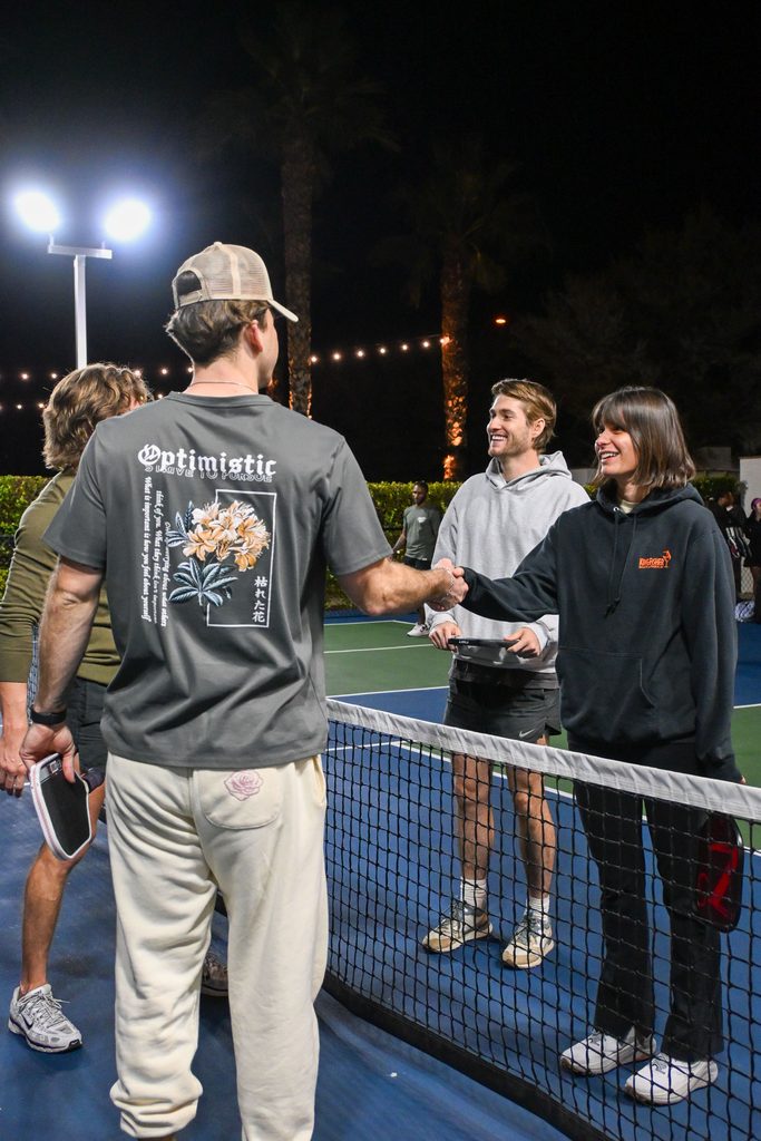 Rencontre : « Joueurs de pickleball se saluant au filet après une partie »