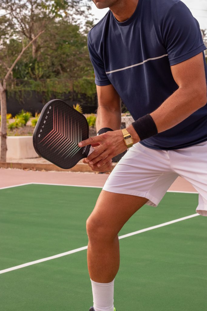 Joueur : « Joueur de pickleball en action sur un terrain extérieur »